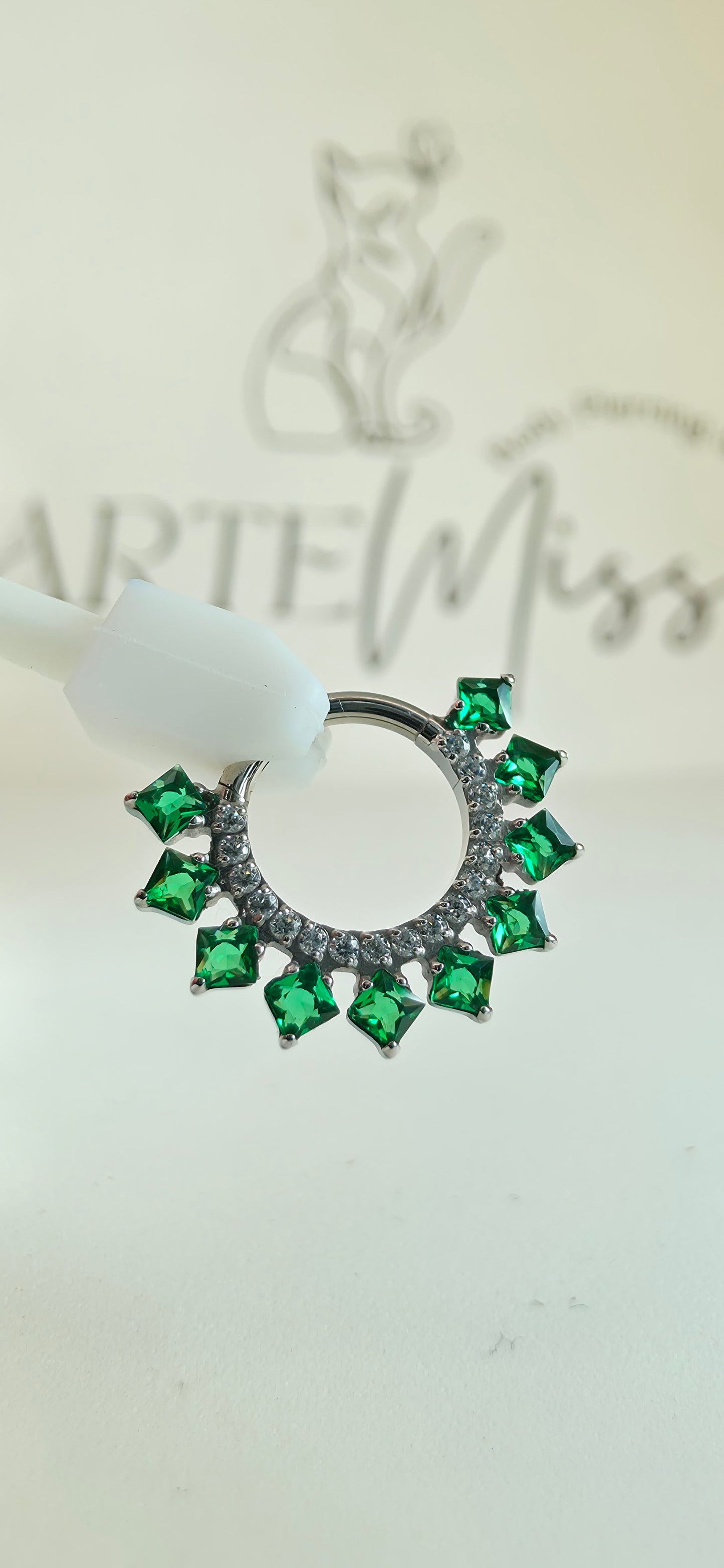 Clicker de Titanio con incrustaciones de zirconia color verde esmeralda.