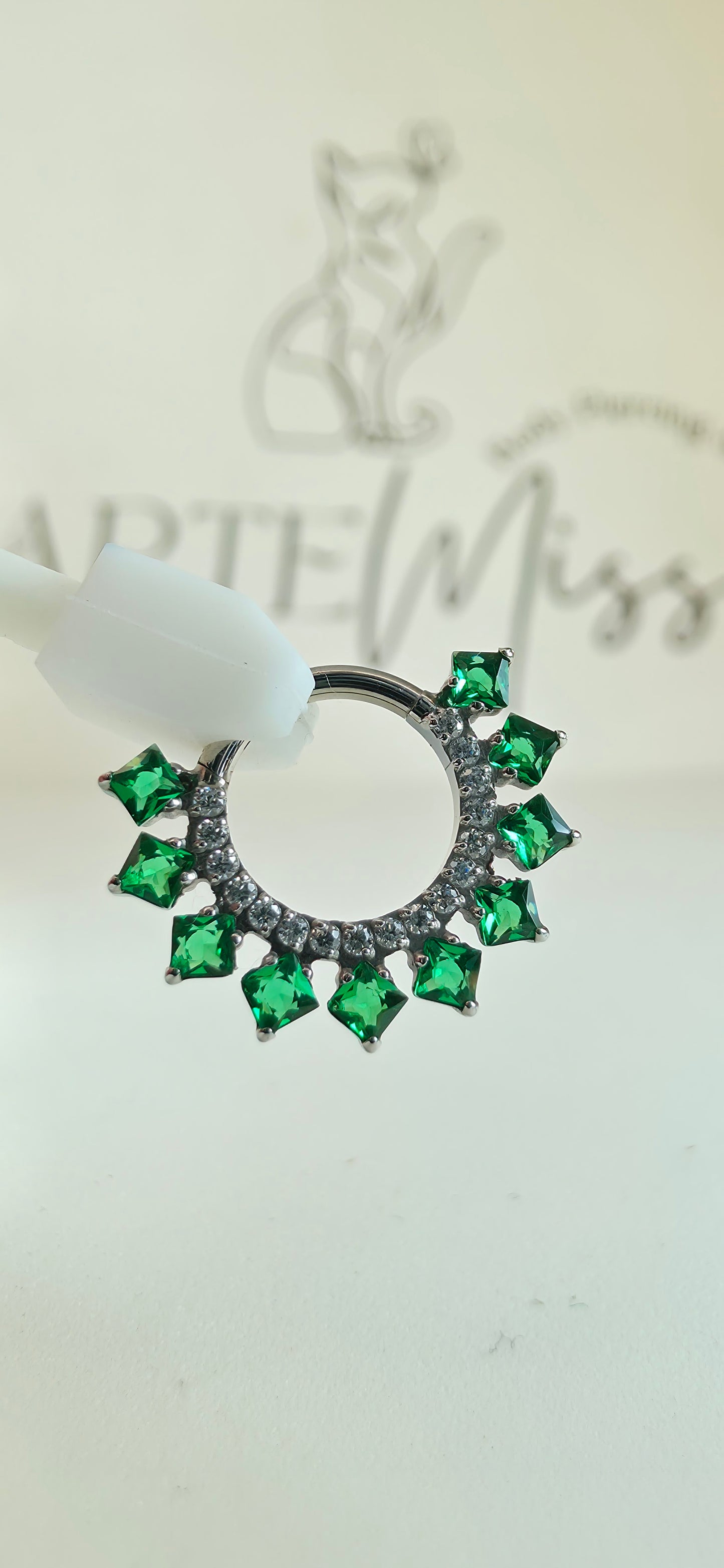 Clicker de Titanio con incrustaciones de zirconia color verde esmeralda.