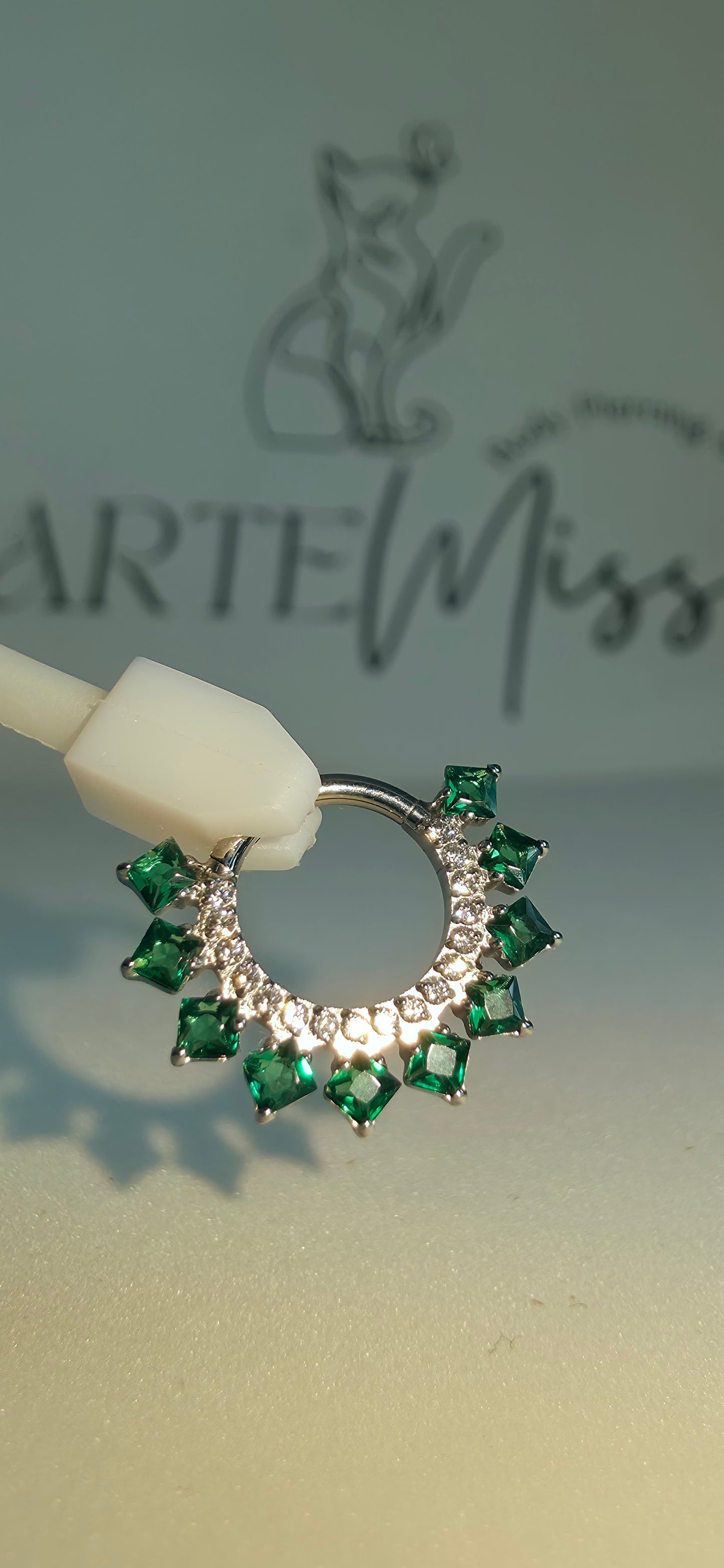 Clicker de Titanio con incrustaciones de zirconia color verde esmeralda.